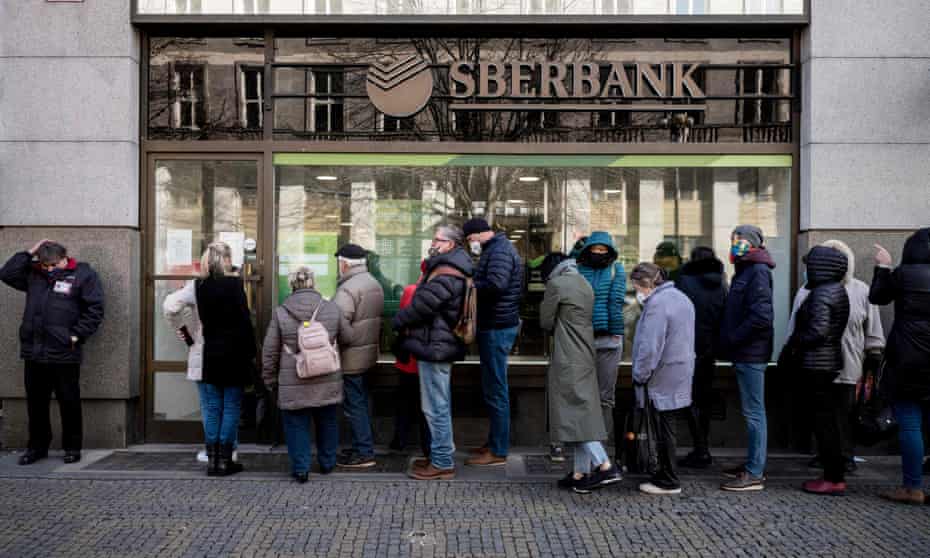 People queue outside a branch of Russian state-owned bank Sberbank to withdraw their savings and close their accounts in Prague