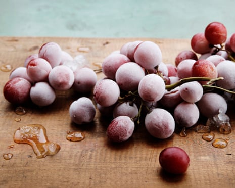 Frozen red grapes on wooden chopping boardGettyImages-1133006340