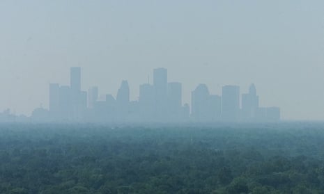 The skyline of downtown Houston is shown with a layer of smog covering it.
