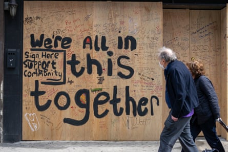 'We're all in this together' painted on to a boarded-up bar in New York City
