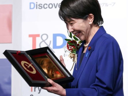 Sanae Takaichi smiles as she receives the award for buzzword of the year for her phrase ‘I will work, work, work, work, and work.’