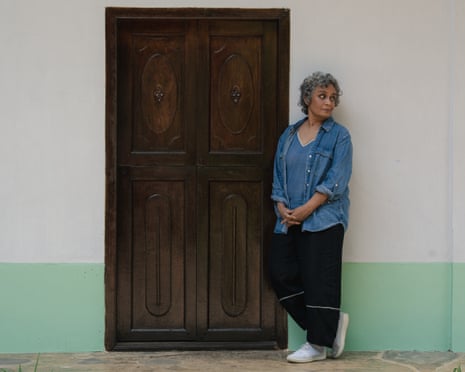 Arundhati Roy standing by a door