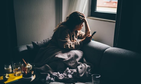 sad young woman on a couch looking out of window