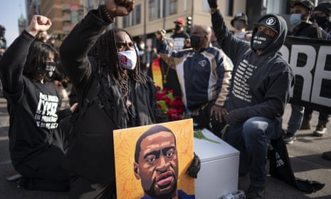 Cortez Rice, left, of Minneapolis, sits with others in the middle of Hennepin Avenue on Sunday, March 7, 2021, in Minneapolis, Minn., to mourn the death of George Floyd a day before jury selection is set to begin in the trial of former Minneapolis officer Derek Chauvin, who is charged in Floyd’s death. (Jerry Holt/Star Tribune via AP)