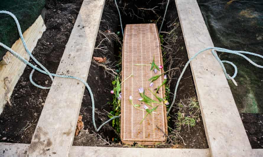 A wicker coffin in a new grave, after a burial service at a cemetery in England. A wicker coffin in a new grave, after a burial service at a cemetery in England.
