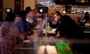 A bartender fist bumps a customer through a plastic barrier at Arnaldo Richards’ Picos in Houston, Texas, on 1 May.