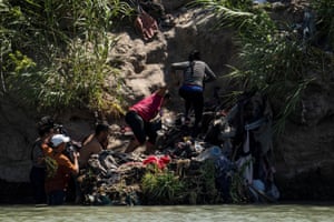 Asylum seeking migrants climb up the bank of the Rio Grande after crossing from Piedras Negras in Mexico into the US