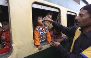 A health worker gives a polio vaccination to a child in a Karachi railway station in Pakistan, 18 November 2019.