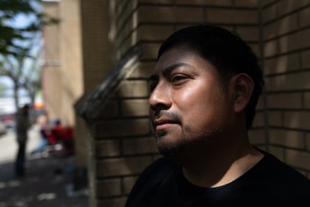 a man looks to the side, his face partly covered in shadows