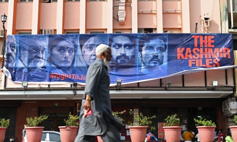 A man walks past a banner for The Kashmir Files in Delhi.