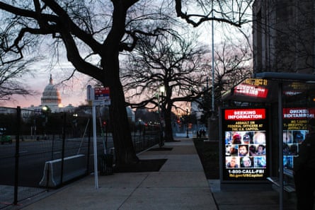 A wanted poster (R) by the FBI is displayed at a bus stop in the now-fenced Independence avenue southwest near the US Capitol (L), as security perimeters expand ahead of the inauguration in Washington, DC, USA, 18 January 2021. The FBI is seeking the public’s help in identifying the insurrectionists that stormed the US Capitol as the Congress worked to certify the electoral votes for the Presidential election.