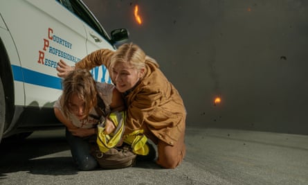 Two women shelter from smoke and flames next to police car