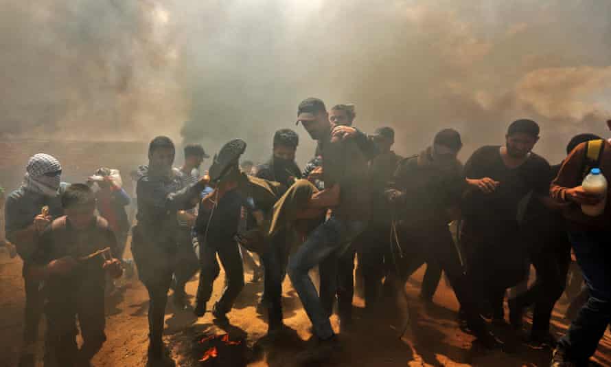Palestinians carry a demonstrator injured during the clashes.