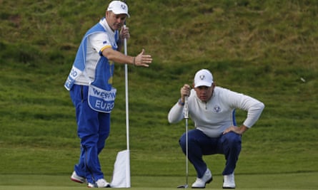 Team Europe’s Lee Westwood and caddie Billy Foster line up a putt on the 7th green in Gleneagles in 2014.