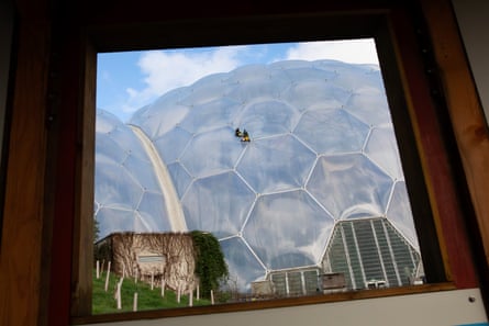 Two men abseiling down the side of the rainforest biome