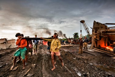 Shipbreaking workers carrying metal sheets. Rahman Yard, Chittagong, Bangladesh.