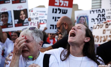 demonstration with two women weeping in foreground and banners