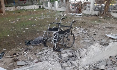 A mangled wheelchair sits among debris