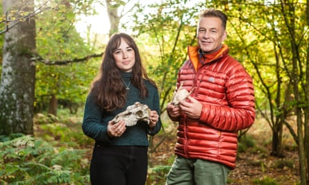 Chris Packham and Megan McCubbin standing in woodland holding skulls