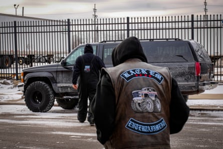 Men wearing hoodies walk towards a 4x4 truck