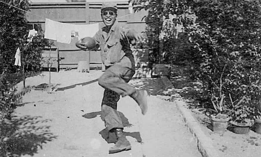 Horse Yoshinaga poses with a football during his army days