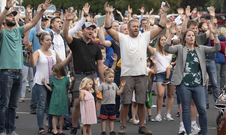 Christ Church members and guests sing in protest of a city public-health order intentionally not wearing masks outside City Hall in Moscow, Idaho, last year.