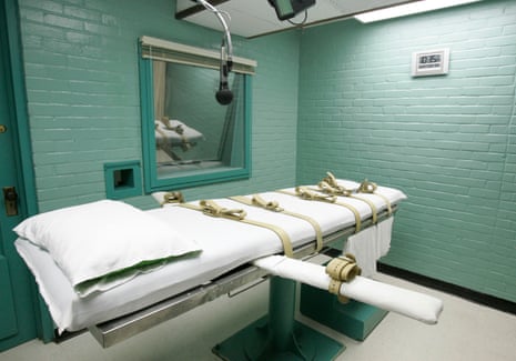 Texas execution chamber gurney with leather restraints beside a viewing window