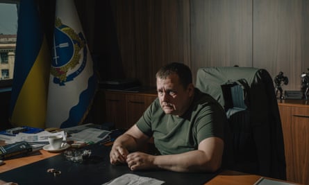Man sitting in office at desk in green T.shirt