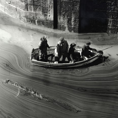 Servicemen survey the oil slick in the harbour at Porthleven, Cornwall.