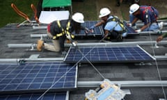 Workers put solar panels down during an installation May 3, 2106 in Washington, DC.