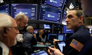 Traders await price updates of Spotify before the company’s direct listing on the floor of the New York Stock Exchange on Tuesday.