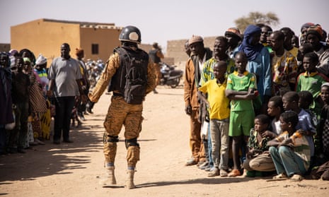 A Burkina Faso soldier patrols at a camp sheltering refugees from the fighting in Dori, in the north of the country.