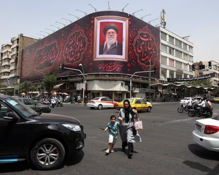 A portrait of Khamenei displayed on a billboard at a busy crossroads