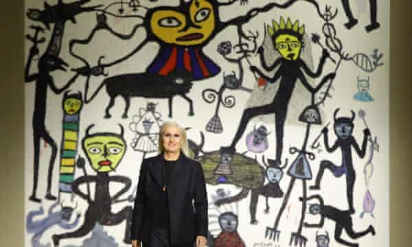 Dior designer Maria Grazia Chiuri on the catwalk in front of a tapestry inspired by the work of Indian artist Madhvi Parekh.
