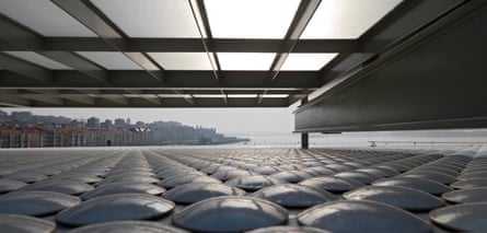 The view from under the gallery. The pearlescent discs adorning parts of the building resemble glittering barnacles.
