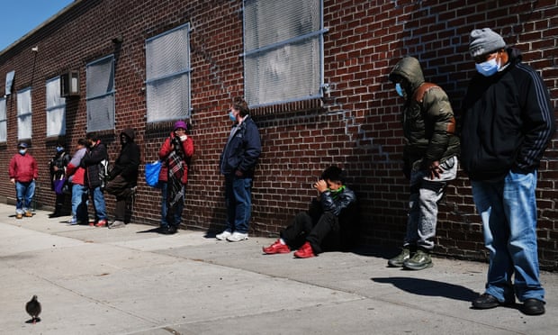 People wait in line to receive food at a food bank in Brooklyn, New York, April 28, 2020. 