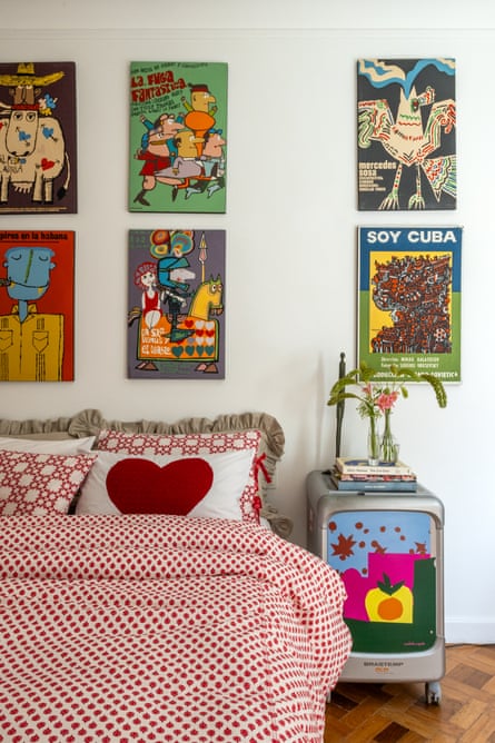 Bedroom in the Rio apartment, with a collection of posters on the wall and a brightly painted bedside table.
