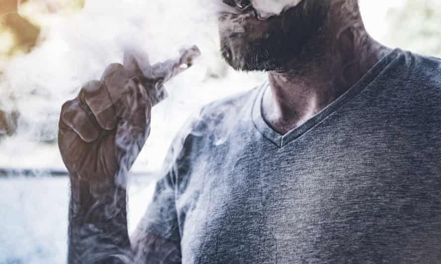 A man smokes an e-cigarette.