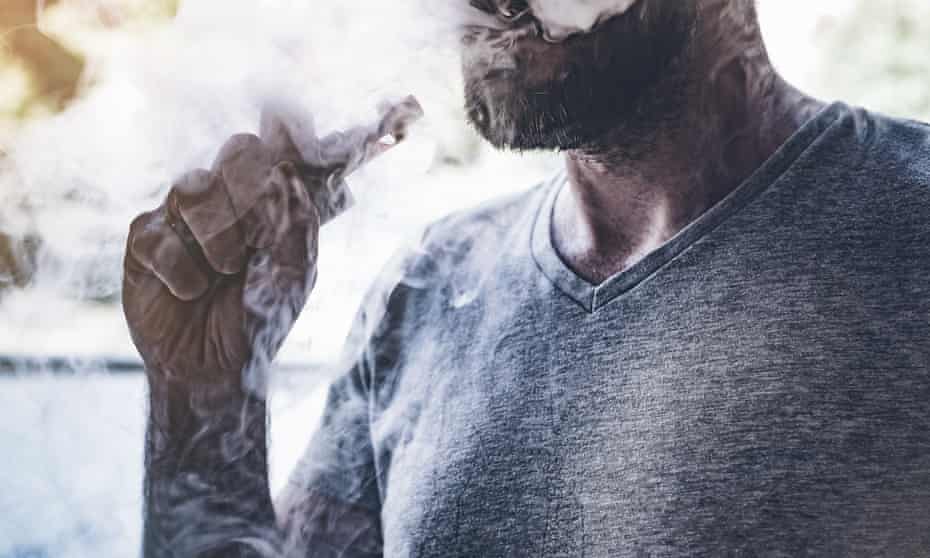A man smokes an e-cigarette.