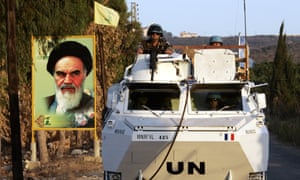 UN peacekeepers pass a sign that shows the late Iranian leader, Aiatollah Khomeini, after the war between Israel and Hezbollah in southern Lebanon, September 2006