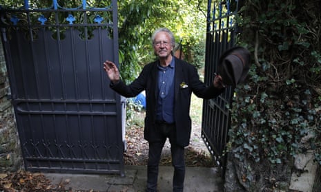 Austrian author Peter Handk greets the press outside his house in Chaville near Paris, on Thursday.