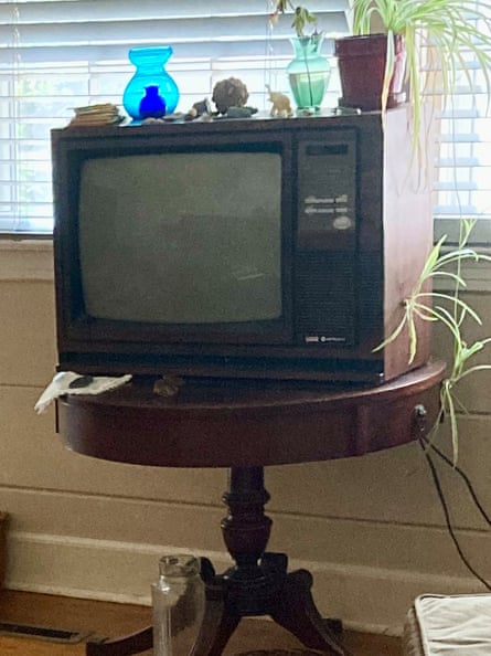 An old-style TV with a wooden surround and the control panel to the right of the screen sits on a side table