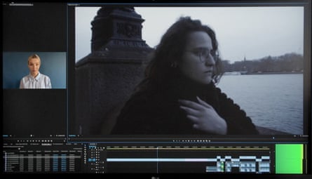 A computer screen with a window showing footage of a woman by the Thames, and another window with an AI face, and data