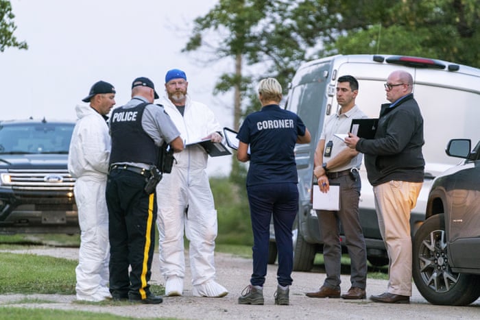 Investigators gather in front of the scene of a stabbing in Weldon, Saskatchewan.