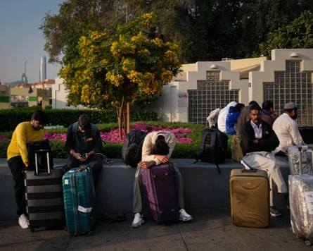 People sit with their suitcases