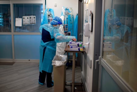 A healthcare worker puts on gloves in the ICU at Oakbend Medical Center in Richmond, Texas, on 15 July.