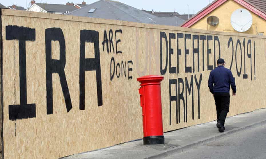 A man walks past graffiti that has been amended to read “IRA are done” in the Creggan area of Derry in Northern Ireland on April 20, 2019 close to where Lyra McKee was shot.