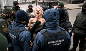 Police officers arrest an activist of Femen movement protesting outside Ukrainian President’s to mark the International Day for the Elimination of Violence against Women in Kiev on 25 November 2020.