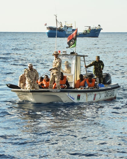 Libyan coastguard officials with people rescued from a dinghy in distress in November 2016.