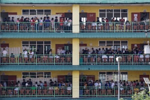 Queues of people on three storeys of a school building